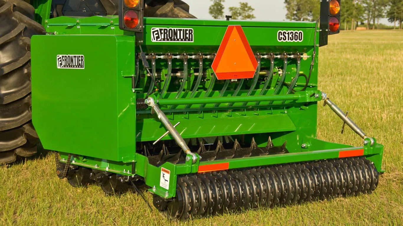 A red combine harvester in action during summer harvest in a lush green countryside.